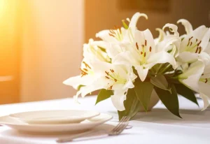 Arranjo-de-mesa-com-lirios-brancos-e-folhagens-tropicais-em-mesa-posta-elegante-em-Campinas.