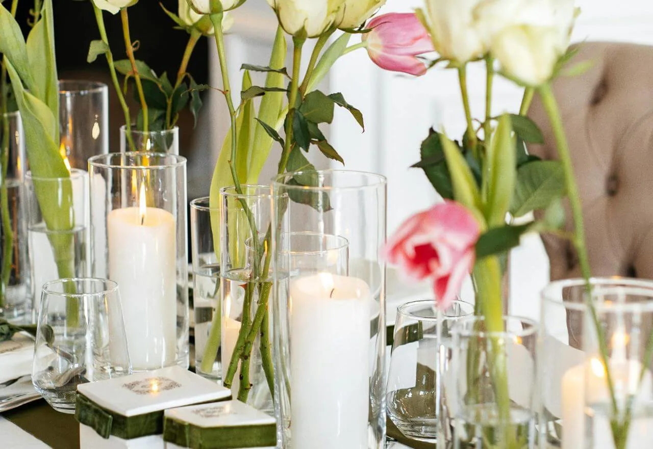 Mesa posta em Campinas com guardanapo de linho, velas acesas e louça branca sofisticada.