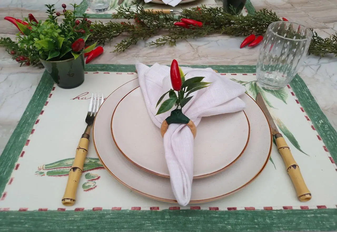 mesa decorada com cipreste e pimenta vermelha e um belo jogo americano