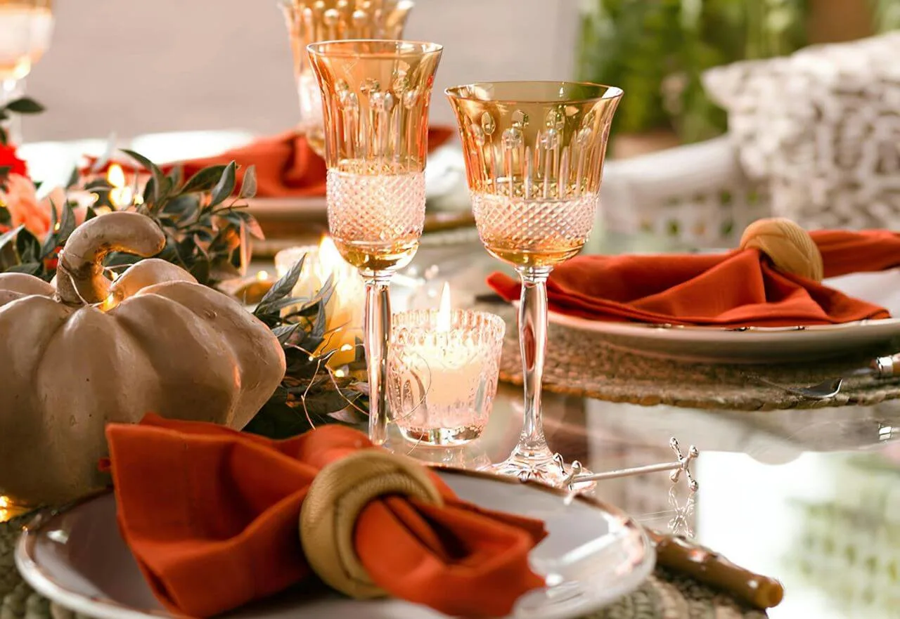 Mesa-posta-decorada-com-tacas-douradas-guardanapos-laranja-e-centro-de-mesa-com-abobora-e-velas-em-Ribeirao-Preto